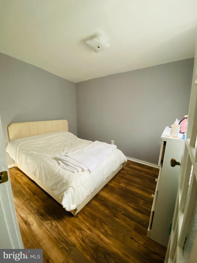 bedroom with dark hardwood / wood-style floors