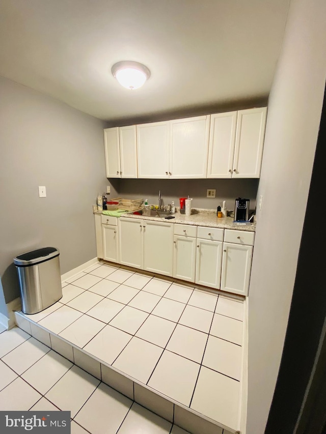 kitchen with sink, white cabinets, and light tile patterned floors