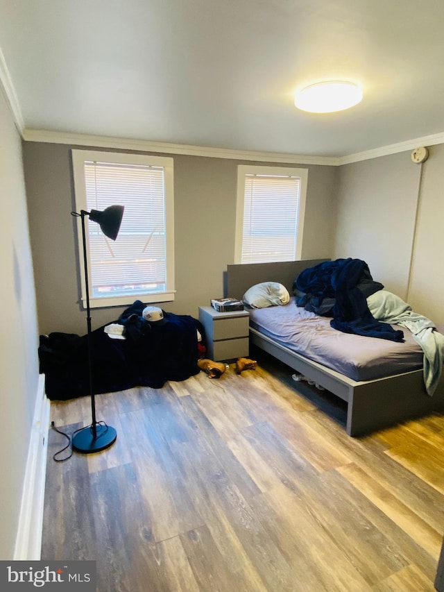 bedroom featuring ornamental molding and hardwood / wood-style floors