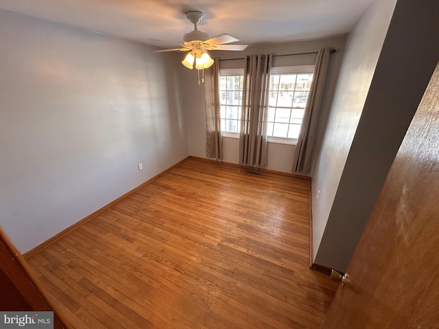 empty room with ceiling fan and light hardwood / wood-style floors