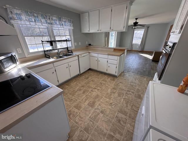 kitchen featuring white cabinets, ceiling fan, sink, kitchen peninsula, and white dishwasher