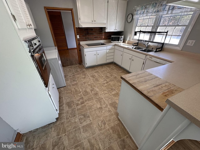 kitchen with white cabinets, dishwasher, washer / clothes dryer, sink, and black electric cooktop