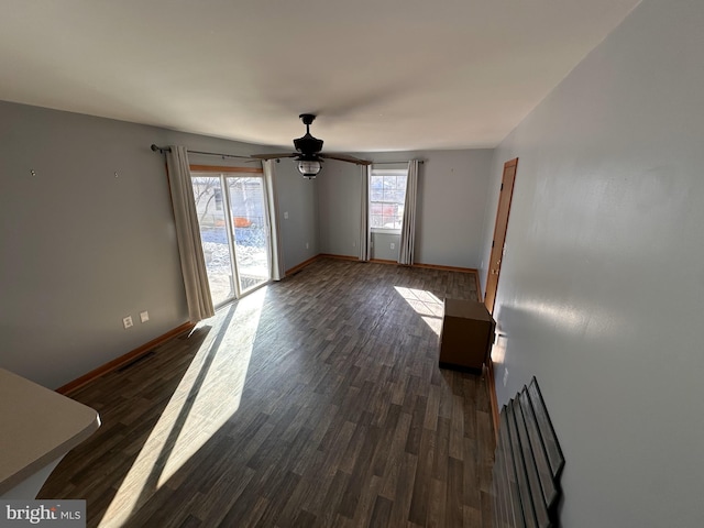 empty room with ceiling fan and dark hardwood / wood-style flooring