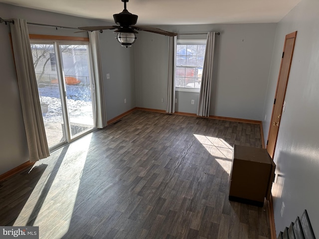 empty room featuring dark wood-type flooring and ceiling fan