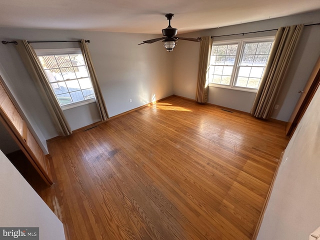 spare room with ceiling fan, plenty of natural light, and light hardwood / wood-style floors