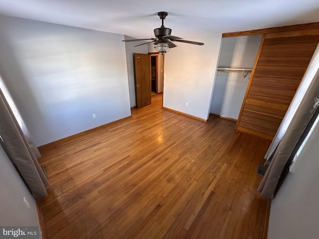 unfurnished bedroom with ceiling fan, hardwood / wood-style floors, and a closet