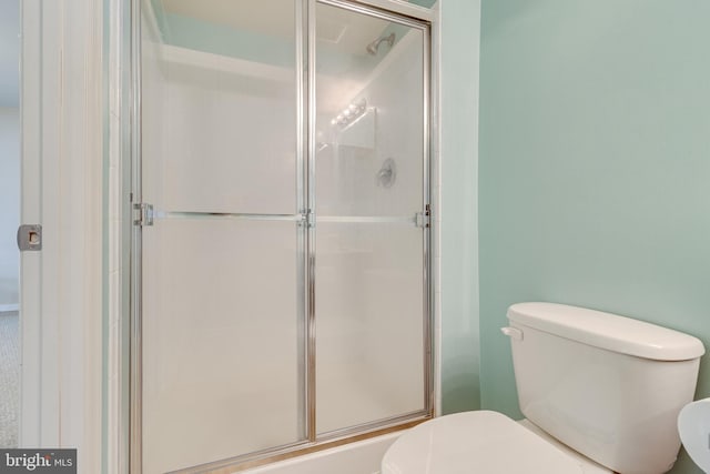 bathroom featuring walk in shower and toilet