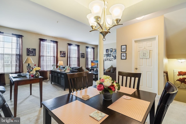 carpeted dining area featuring a chandelier