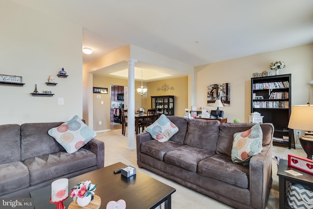 living room with decorative columns, light carpet, and a tray ceiling