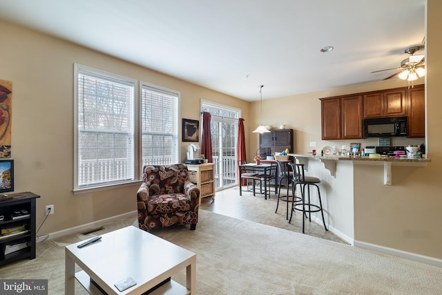 carpeted living room featuring ceiling fan