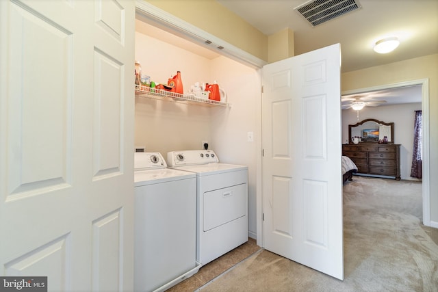 clothes washing area featuring light colored carpet and independent washer and dryer