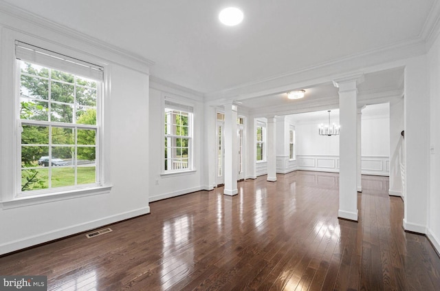 unfurnished living room with crown molding, dark hardwood / wood-style floors, and an inviting chandelier