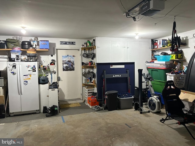 garage with white fridge and a garage door opener