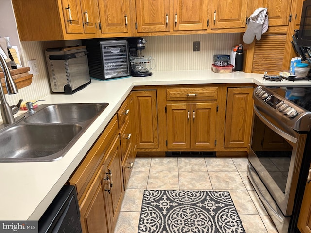 kitchen featuring light tile patterned flooring, sink, dishwasher, and electric stove