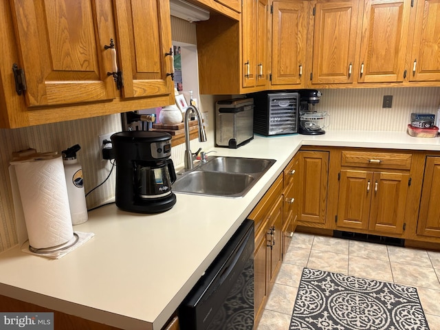 kitchen with dishwasher, light tile patterned floors, and sink