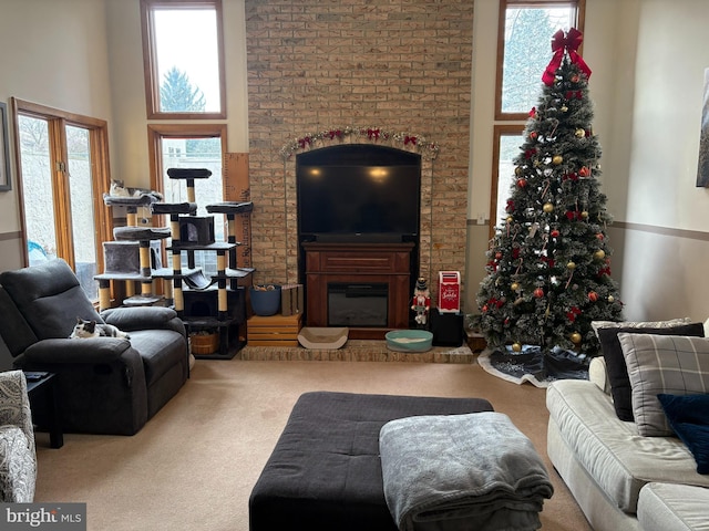 living room featuring carpet, a towering ceiling, and a wealth of natural light