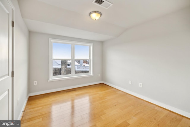 unfurnished room featuring light hardwood / wood-style floors and lofted ceiling