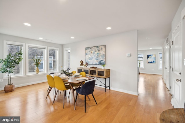 dining room featuring light wood-type flooring and a healthy amount of sunlight