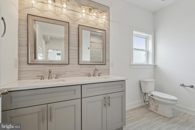 bathroom featuring vanity, backsplash, hardwood / wood-style flooring, and toilet