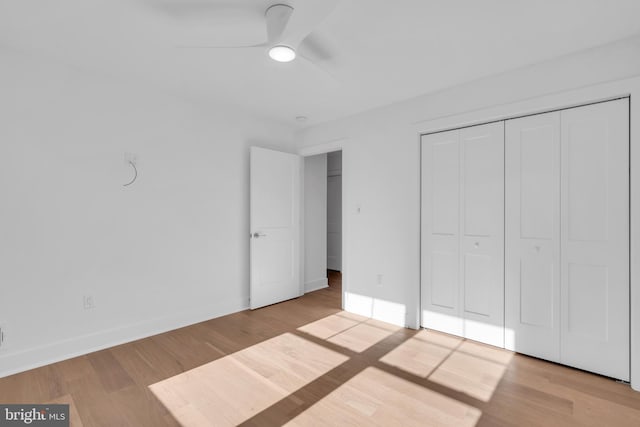 unfurnished bedroom with ceiling fan, a closet, and light hardwood / wood-style flooring