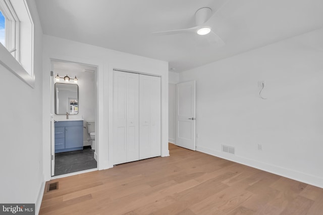 unfurnished bedroom with ceiling fan, connected bathroom, light hardwood / wood-style floors, and a closet