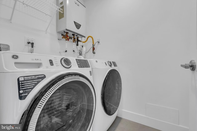 clothes washing area featuring washing machine and clothes dryer and water heater