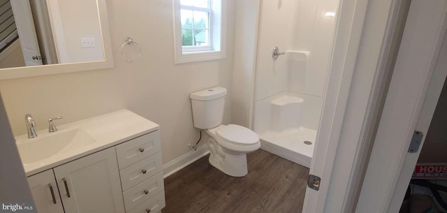 bathroom with hardwood / wood-style flooring, vanity, toilet, and walk in shower