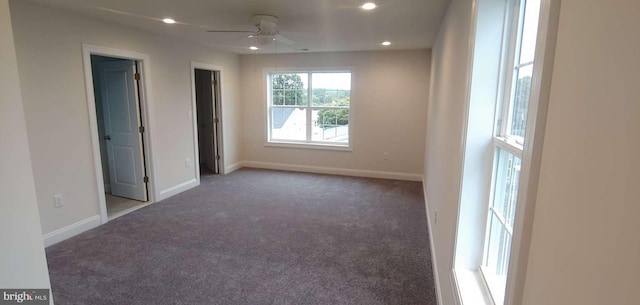 carpeted spare room featuring ceiling fan