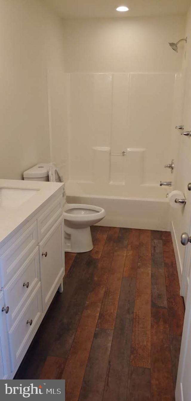 full bathroom featuring shower / tub combination, vanity, wood-type flooring, and toilet