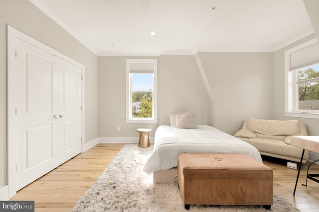 bedroom featuring light wood-type flooring and crown molding