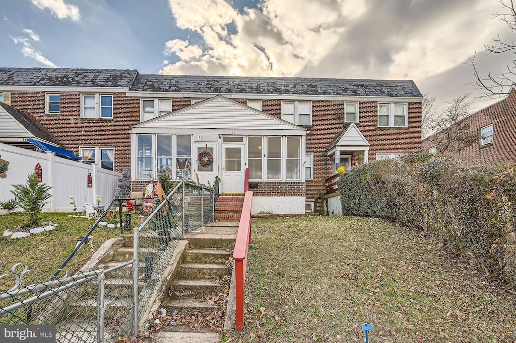 view of front of property featuring a sunroom and a front yard