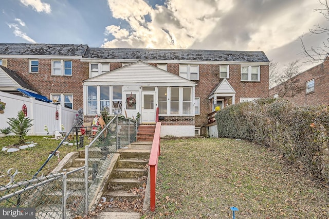 view of front of property featuring a sunroom and a front yard