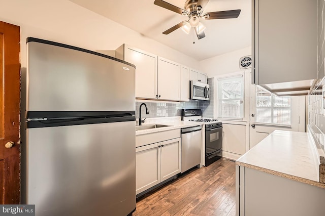 kitchen featuring white cabinetry, sink, light hardwood / wood-style flooring, decorative backsplash, and appliances with stainless steel finishes