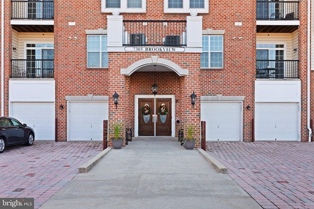 view of exterior entry featuring a garage and french doors