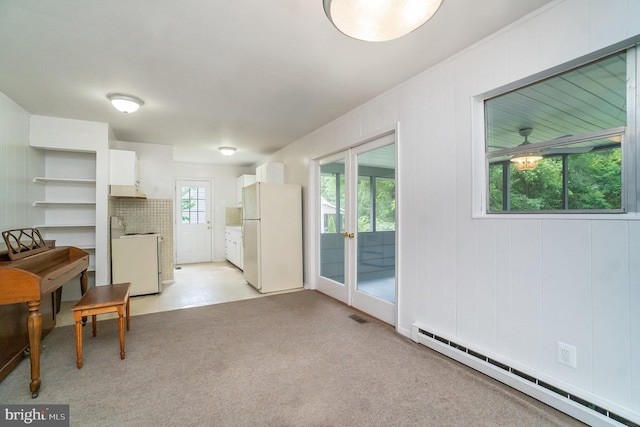 kitchen with white cabinetry, a baseboard radiator, white refrigerator, stove, and light colored carpet