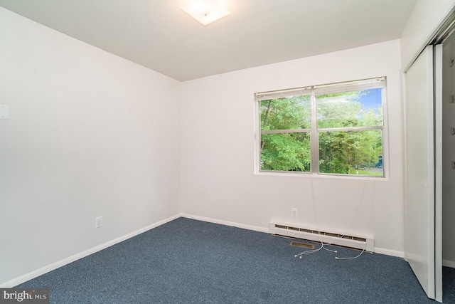 spare room featuring carpet flooring and a baseboard radiator