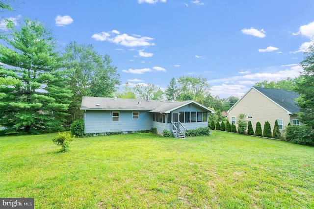 back of house with a sunroom and a yard