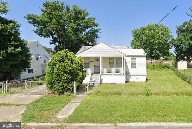 bungalow-style house featuring covered porch and a front yard