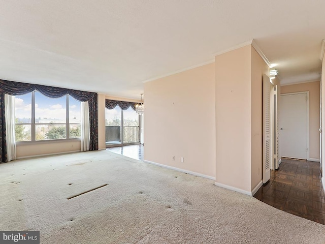 carpeted empty room featuring crown molding and an inviting chandelier