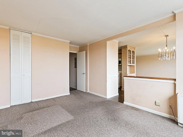 unfurnished room with a chandelier, carpet, and crown molding