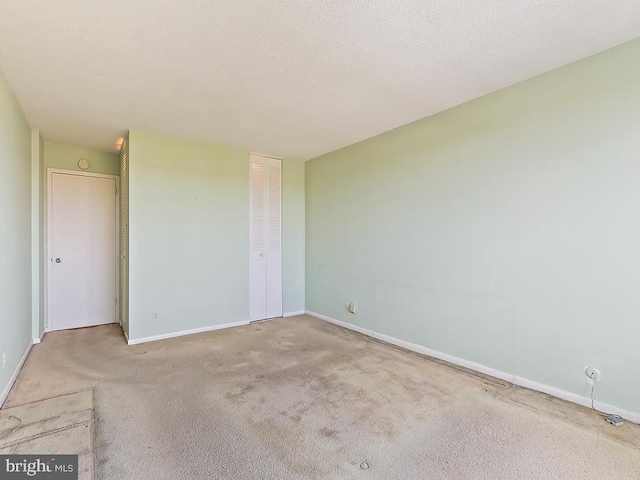 carpeted empty room with a textured ceiling