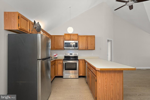 kitchen featuring appliances with stainless steel finishes, brown cabinetry, light countertops, and a peninsula