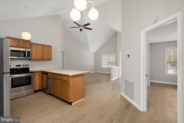 kitchen featuring a peninsula, visible vents, light countertops, appliances with stainless steel finishes, and light wood-type flooring