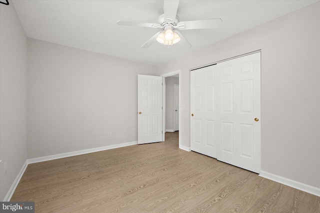 unfurnished bedroom with a ceiling fan, a closet, light wood-style flooring, and baseboards