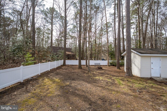 view of yard with an outbuilding, a fenced backyard, and a storage unit