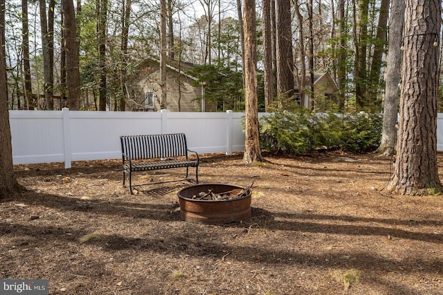 view of yard with a fire pit and fence