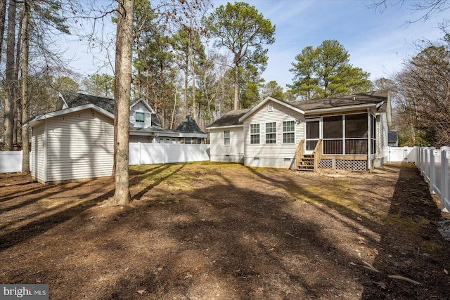 rear view of house with entry steps, crawl space, a fenced backyard, and a sunroom