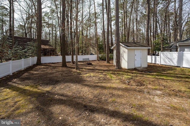 view of yard featuring an outbuilding, a storage unit, and a fenced backyard