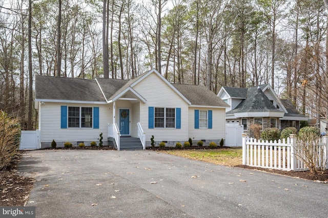 ranch-style home with a shingled roof, crawl space, and fence