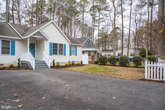 view of front of house with crawl space, fence, and roof with shingles